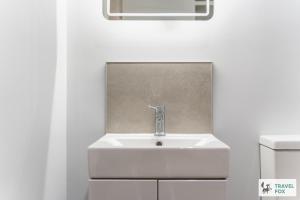a sink in a bathroom with a white wall at Blair's Central Stay in Nottingham