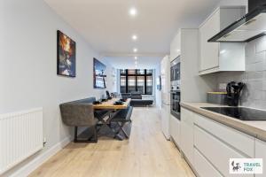 a kitchen with white cabinets and a wooden table at Blair's Central Stay in Nottingham