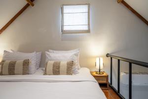 a bedroom with a bed with white sheets and a window at Balance, Beauty and WiFi - Find It All at Sarang Apartments 2 in Ubud