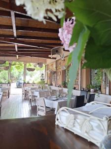 a restaurant with white tables and chairs and flowers at Pensiunea Boema in Lancrăm
