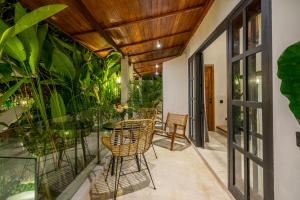 an outdoor patio with chairs and tables and plants at Balance, Beauty and WiFi - Find It All at Sarang Apartments 2 in Ubud