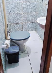a bathroom with a blue toilet and a sink at suíte feliz in Belém +14 photos