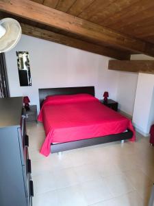 a red bed in a room with a wooden ceiling at MAREMONTI alloggio turistico in Formia