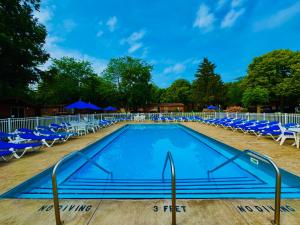 a swimming pool with blue chairs and blue umbrellas at Put-in-Bay Island Club #51 in Put-in-Bay