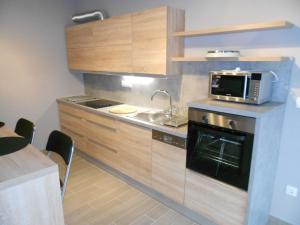 a small kitchen with a sink and a microwave at Gabi Papa Apartman in Pécs
