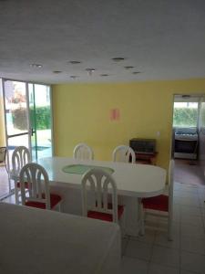 a dining room with a white table and chairs at Casa coco in Texcalpan