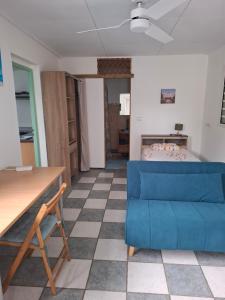 ein Wohnzimmer mit einer blauen Couch und einem Bett in der Unterkunft Ti Kaz Fifine, bord de mer in Sainte-Anne