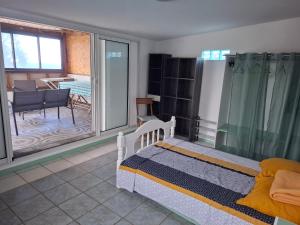 ein Schlafzimmer mit Bett und Blick auf ein Wohnzimmer in der Unterkunft Ti Kaz Fifine, bord de mer in Sainte-Anne