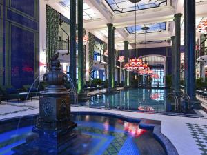 a lobby with a swimming pool in a building at Hotel de la Coupole - MGallery in Sa Pa