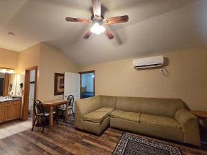 a living room with a couch and a ceiling fan at Texas Star Lodges in Floresville