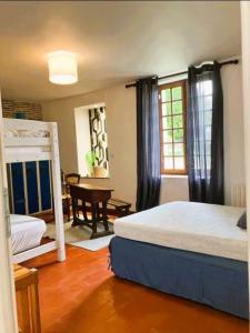 a bedroom with a bed and a desk and a piano at Domaine des Tauperons-8 pers-proche Beauval-wifi in Le Grand-Chambonais
