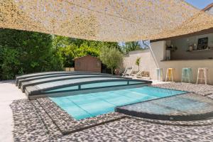 einen Pool im Hinterhof mit Sonnenschirm in der Unterkunft La Maison du Lavoir Charme & Nature proche de Lyon in Saint-Quentin-Fallavier