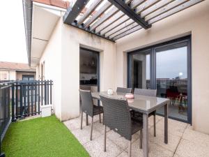 eine Terrasse mit Tisch und Stühlen auf einem Balkon in der Unterkunft LEscale Détente - Genas Lyon Eurexpo St Exupéry in Genas