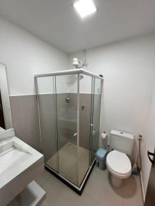 a bathroom with a glass shower and a toilet at Suíte villa in Cayru