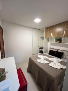 a bedroom with a bed with two white towels on it at Suíte villa in Cayru +7 photos