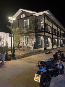 a motorcycle parked in front of a building at night at TheBloomMahasarakham in Maha Sarakham