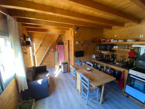 a kitchen and living room with a table in a cabin at chalet bois montagne Urbanya Occitanie in Urbanya