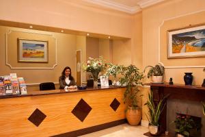 a woman sitting at a counter in a salon at Avon Hotel in London