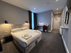 a hotel room with a large bed and a desk at Preston Park Hotel in Brighton & Hove