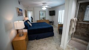 een slaapkamer met een blauw bed en een televisie bij Beachfront Luxury with Spectacular Ocean Views! in Ormond Beach +28 foto's