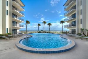een zwembad voor een gebouw met palmbomen bij Beachfront Luxury with Spectacular Ocean Views! in Ormond Beach