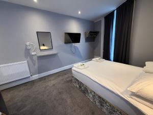 a bedroom with a bed and two monitors on the wall at Preston Park Hotel in Brighton & Hove +28 photos