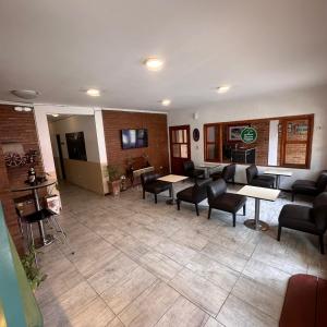 eine Lobby mit Tischen und Stühlen in einem Zimmer in der Unterkunft Rincon Serrano in Carpintería