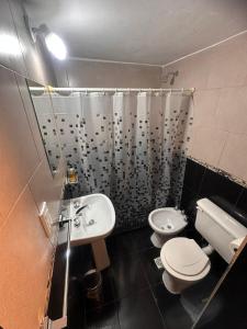 ein Badezimmer mit Waschbecken, Toilette und Dusche in der Unterkunft Rincon Serrano in Carpintería