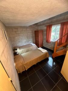 ein kleines Zimmer mit einem Bett und zwei Fenstern in der Unterkunft Rincon Serrano in Carpintería