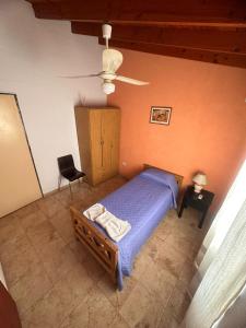 ein Schlafzimmer mit einem Bett und einem Stuhl in einem Zimmer in der Unterkunft Rincon Serrano in Carpintería + 2 Fotos