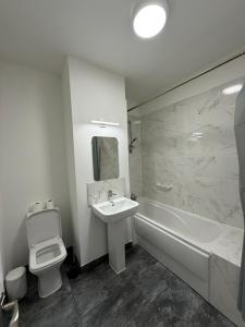 a bathroom with a sink and a toilet and a tub at Preston Park Hotel in Brighton & Hove