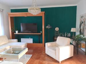 a living room with white furniture and a green wall at Apartman Soda in Ogulin