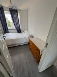 ein kleines Schlafzimmer mit zwei Betten und einem Fenster in der Unterkunft Bronze house in Friern Barnet