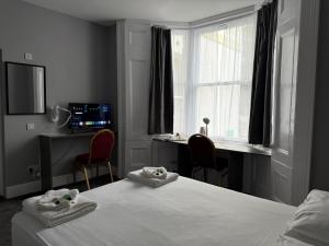 a bedroom with a bed and a desk and a window at Preston Park Hotel in Brighton & Hove