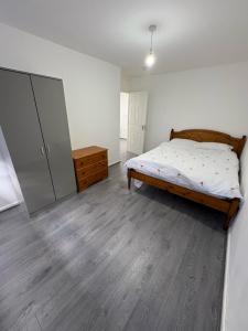 ein Schlafzimmer mit einem Bett und einer Kommode darin in der Unterkunft Bronze house in Friern Barnet