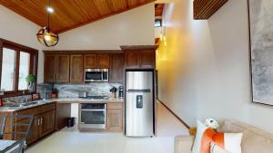 Una cocina con refrigerador de acero inoxidable y gabinetes de madera. en Book And Save Oceanfront Private Estate By Alom, en San Pedro