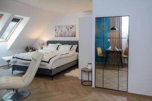 a bedroom with a bed and a chair and a mirror at Bliss & Relax Central Apartment Debrecen, Free Parking in Debrecen