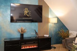 a living room with a tv and a fireplace at Bliss & Relax Central Apartment Debrecen, Free Parking in Debrecen