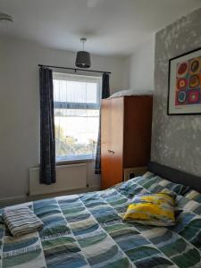 a bedroom with a bed with two pillows and a window at Kettering Town End terrace walking distance to Kettering town in Kettering