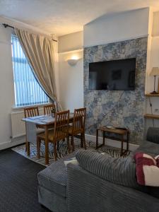 a living room with a table and a couch at Kettering Town End terrace walking distance to Kettering town in Kettering