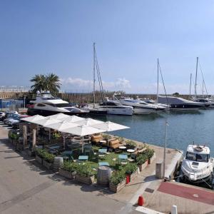 a marina with tables and white umbrellas and boats at Marina Vila House, Vista Playa in El Masnou
