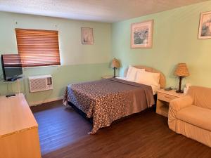 a bedroom with a bed and a couch at THE FLORIDIAN INN in Clearwater