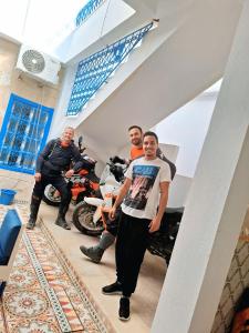 un grupo de hombres parados junto a una motocicleta en Dar Aziz VIP, en Sousse