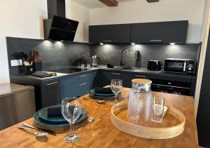 a kitchen with a wooden table with wine glasses on it at Keriana Luxe et détente privée en Alsace in Muttersholtz