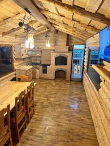 a large room with a fireplace and a table and chairs at Pensiunea Plaiul Bucovinei in Şarul Dornei