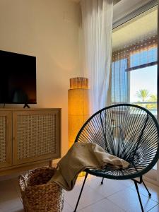 a living room with a chair and a window at Beachfront apartment in El Altet