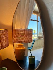 an orange vase sitting on a table in front of a mirror at Beachfront apartment in El Altet