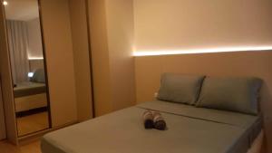 un par de zapatos sentados en una cama en una habitación en Apto com piscina a 150m da Praia!, en Penha