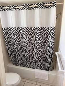 a bathroom with a black and white shower curtain at THE FLORIDIAN INN in Clearwater +14 photos