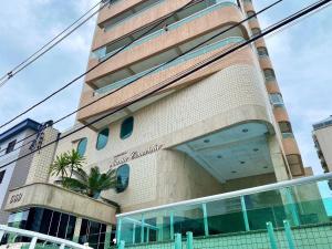 un edificio con una palmera delante en Residencial Maria Conceição, en Samaritá